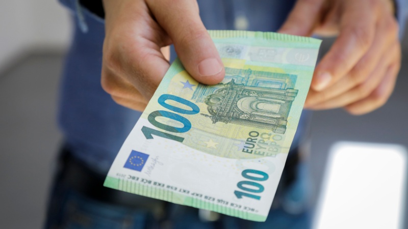 Mano porge banconota da 100 euro